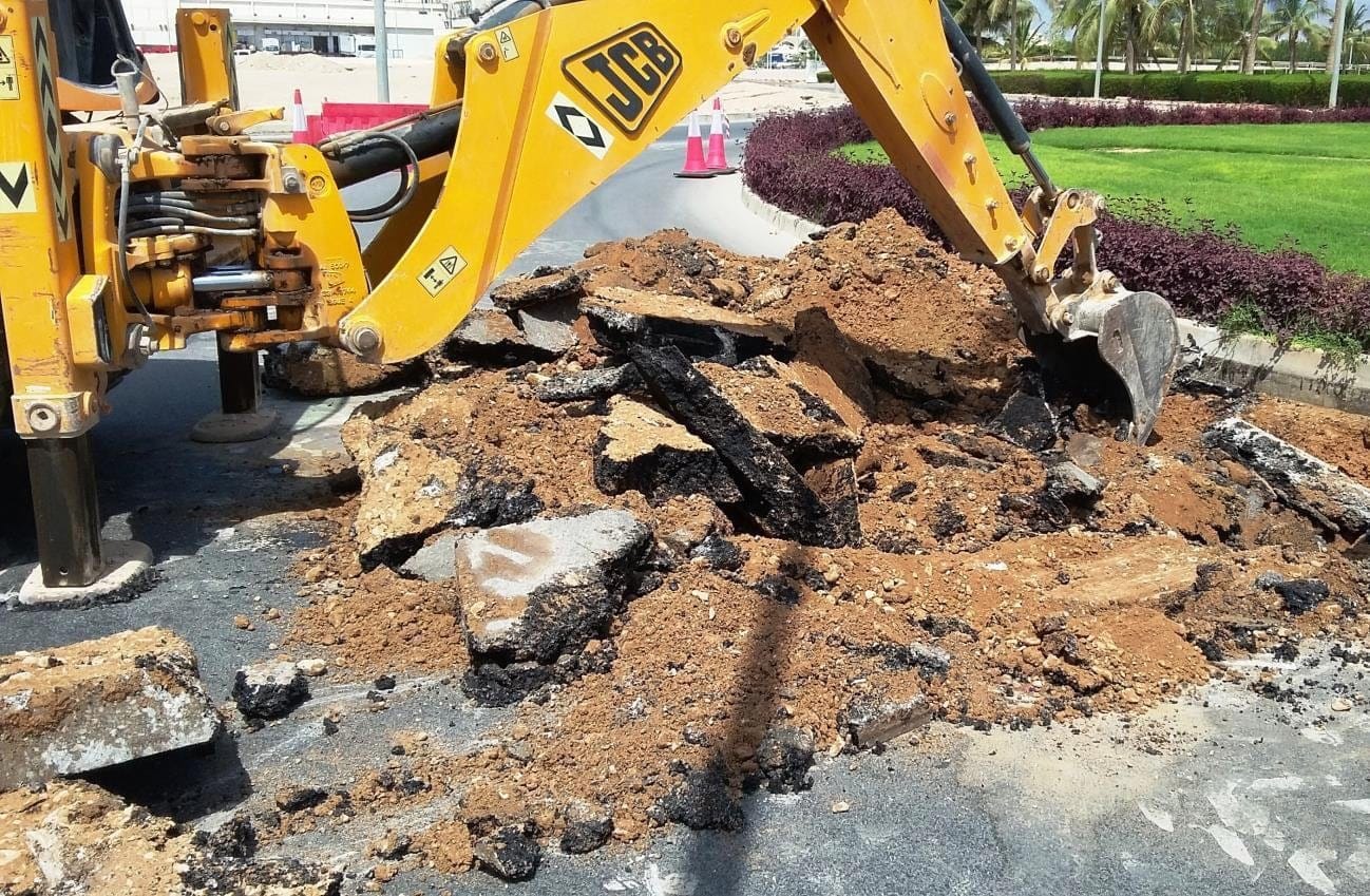 Backhoe loader breaking out an old pavement