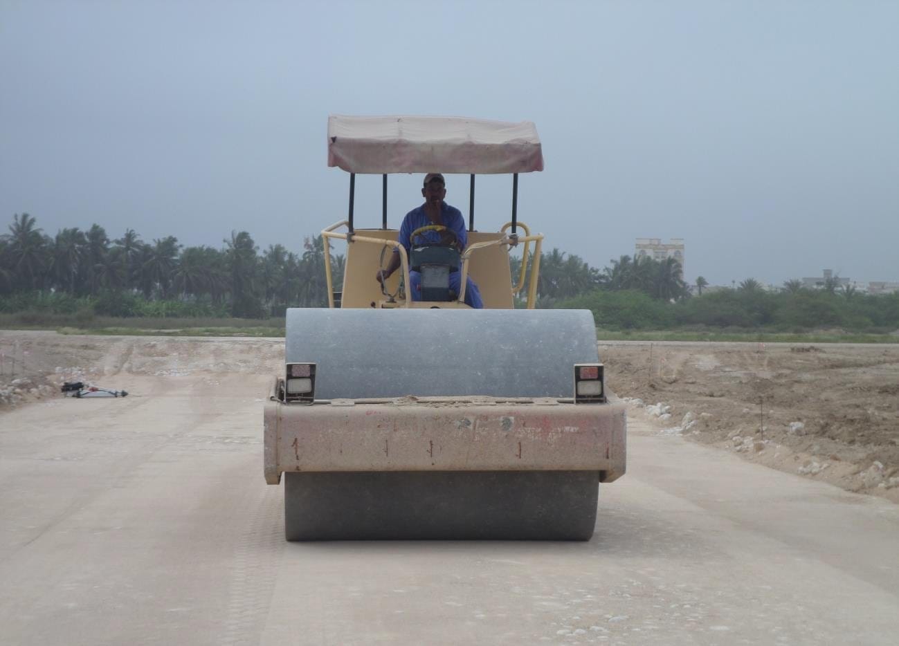 Roller compacting fresh asphalt at a junction