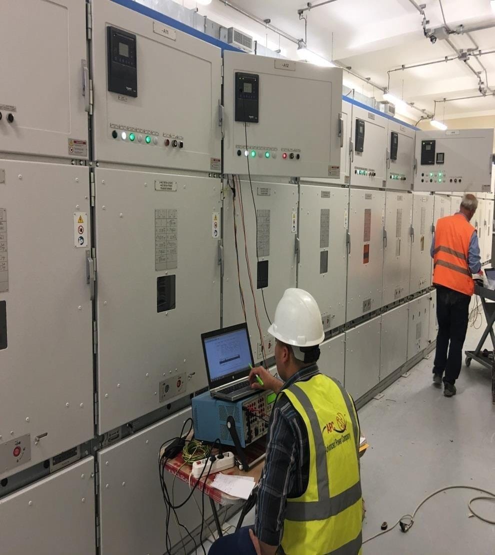 Engineer testing switchgear with a laptop