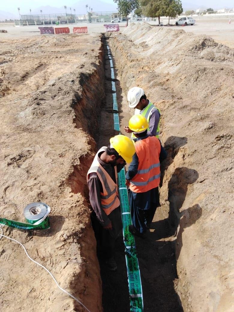 Worker in PPE inside a deep trench